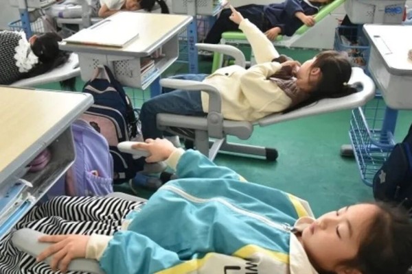 Alunos de escolas chinesas usam cadeiras para tirar uma soneca